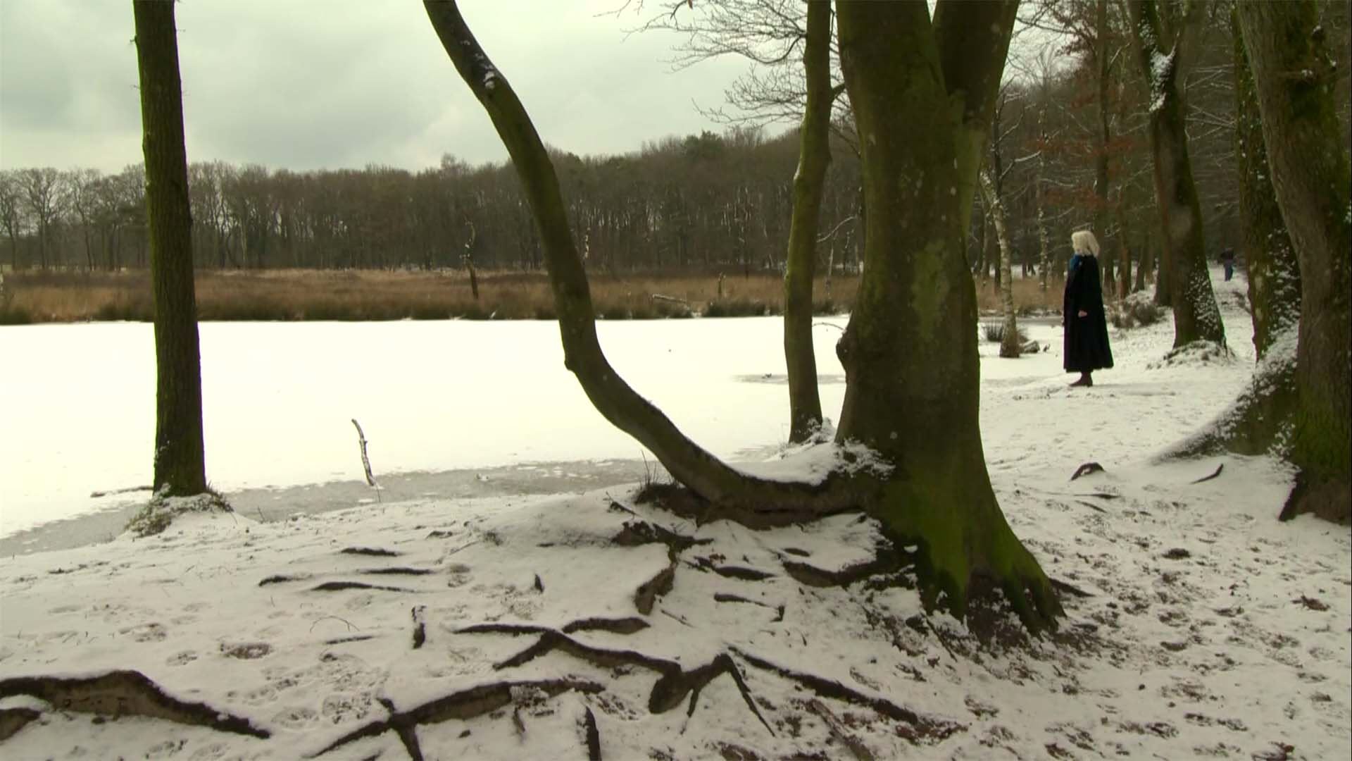 Vrouw kijkt uit over water waar mensen liggen begraven